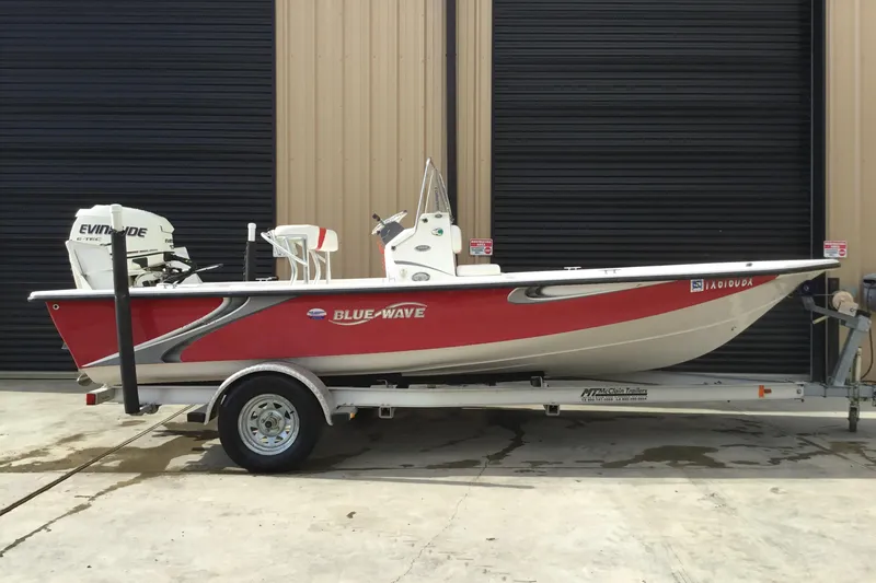 The Image of 2013 Blue Wave 1900 STL boat on trailer, red and white design, parked outdoors. - 1