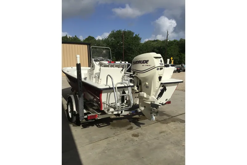 Slide: The Image of 2013 Blue Wave 1900 STL boat with Evinrude motor on trailer, parked outdoors. - 22