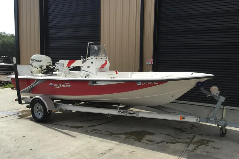 Slide: The Image of 2013 Blue Wave 1900 STL boat on trailer, parked outside a building. - 4