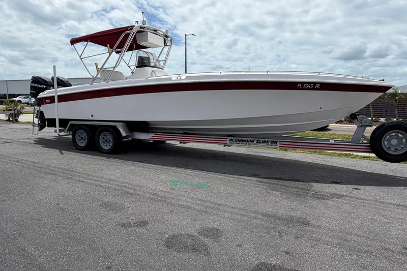 Slide: The Image of 1997 Wellcraft 302 Scarab Sport boat on trailer, featuring red accents and Mercury engines. - 5
