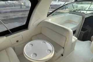 Slide: The Image of 2004 Sea Ray Sundancer 260 cabin interior with cushioned seating and wooden accents. - 18