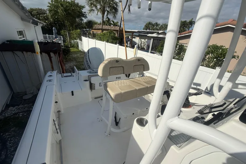 Slide: The Image of 2023 Sea Pro 219 Deep V CC boat interior with seating and console, parked outdoors. - 10
