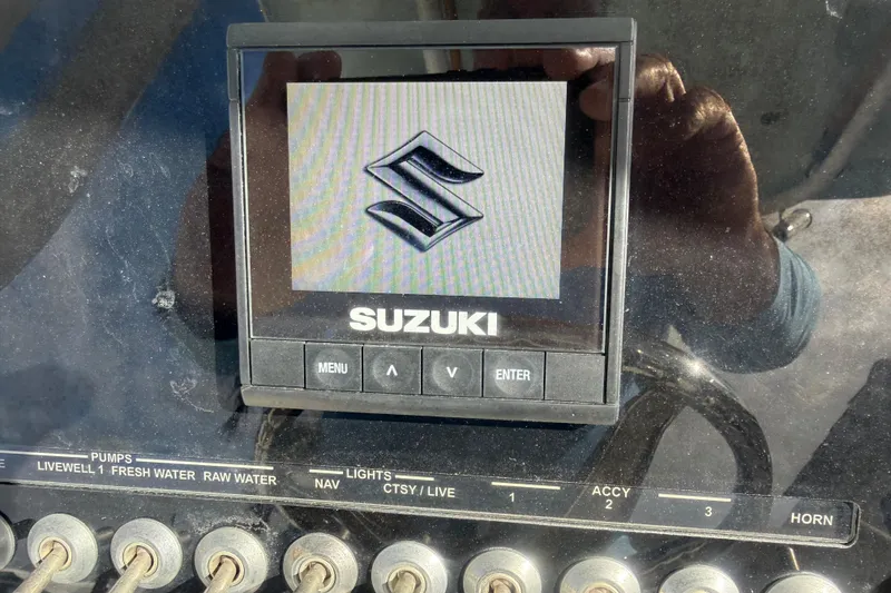Slide: The Image of Suzuki display on 2023 Sea Pro 219 Deep V CC boat dashboard with control switches. - 12
