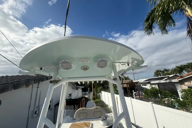 Slide: The Image of 2023 Sea Pro 219 Deep V CC boat with T-top and speakers under a blue sky. - 15