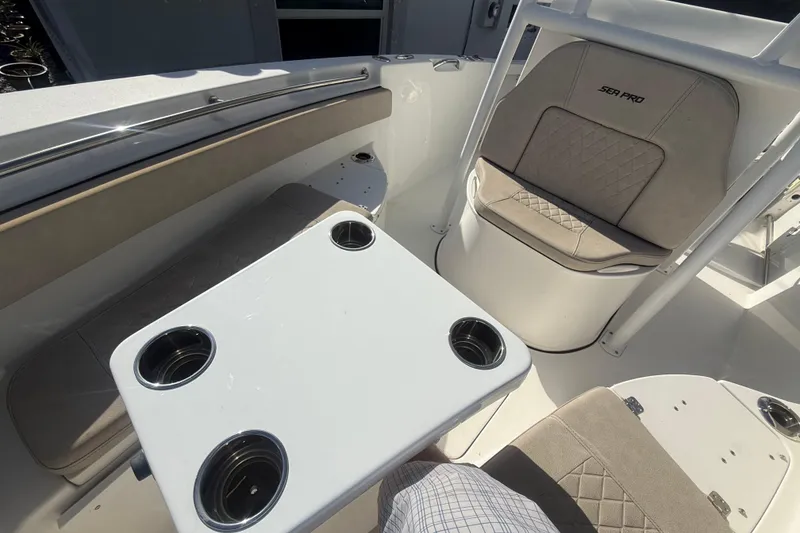 Slide: The Image of 2023 Sea Pro 219 Deep V CC boat interior with seating and cupholder table. - 16