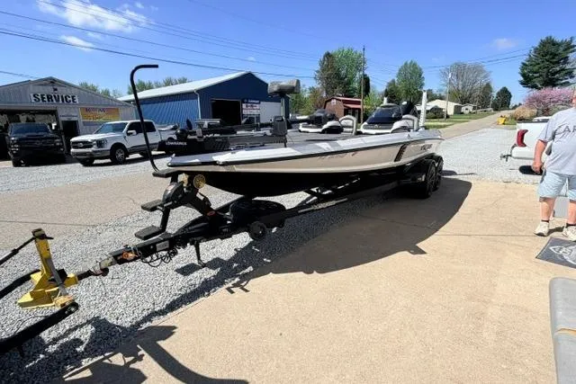 Slide: The Image of 2022 Vexus VX21 boat on trailer in sunny outdoor setting near service shop. - 14