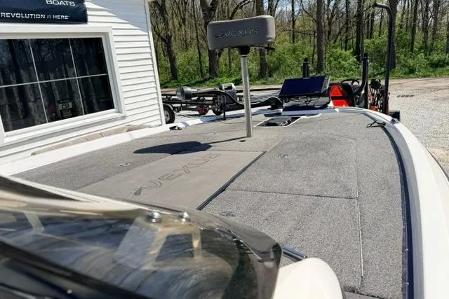 Slide: The Image of 2022 Vexus VX21 boat deck with advanced navigation equipment, parked near a wooded area. - 8