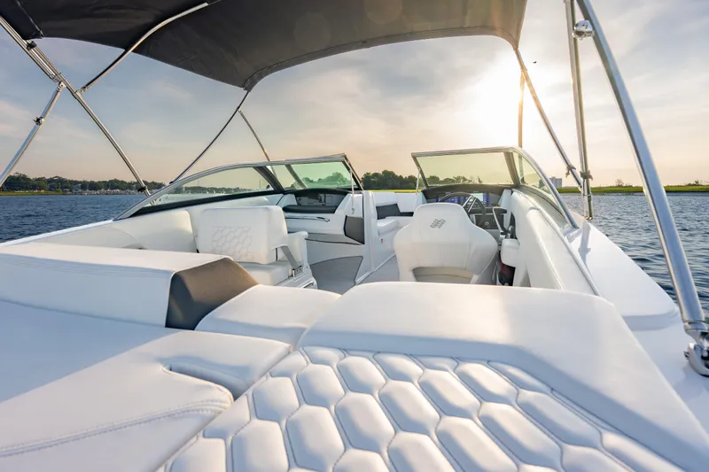 Slide: The Image of 2026 Four Winns H2 OB boat interior with luxurious white seating and sleek design on a sunny day. - 17