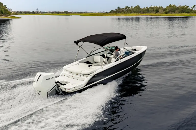 Slide: The Image of 2026 Four Winns H2 OB boat cruising on a calm lake with a Mercury outboard engine. - 4