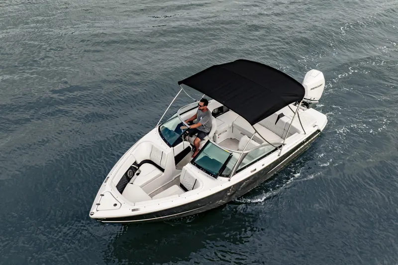Slide: The Image of 2026 Four Winns H2 OB boat cruising on open water with a black canopy. - 10