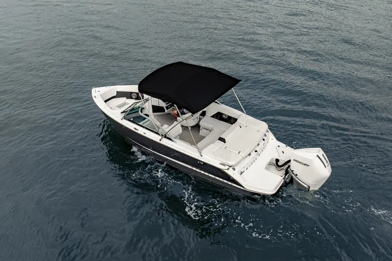 Slide: The Image of 2026 Four Winns H2 OB boat cruising on open water with a black canopy. - 13