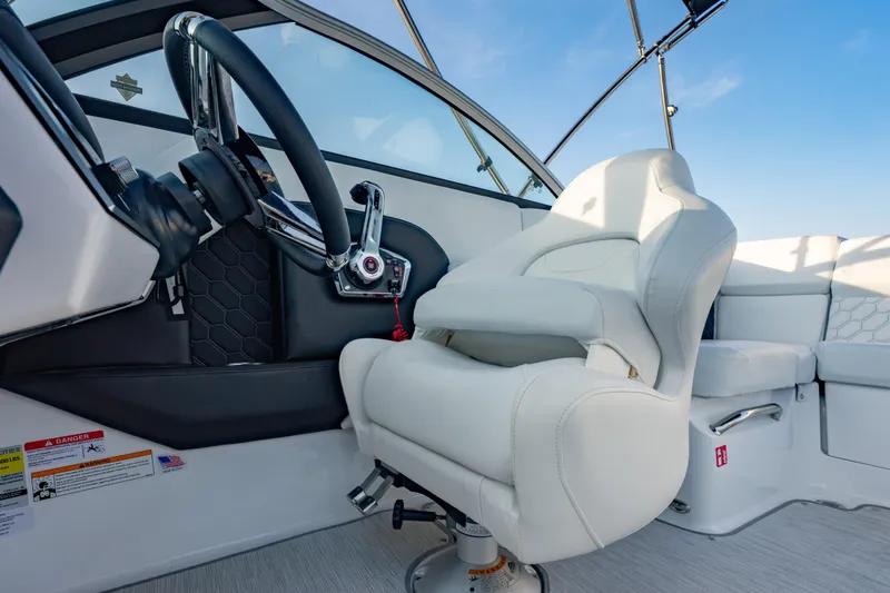 Slide: The Image of Interior of 2026 Four Winns H2 OB boat with white captain's chair and steering wheel. - 24