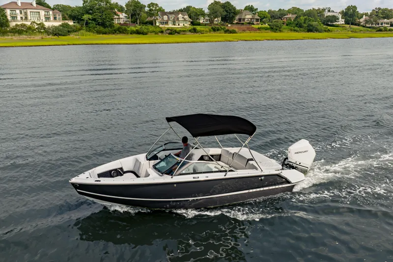 Slide: The Image of 2026 Four Winns H2 OB boat cruising on a scenic lake. - 9