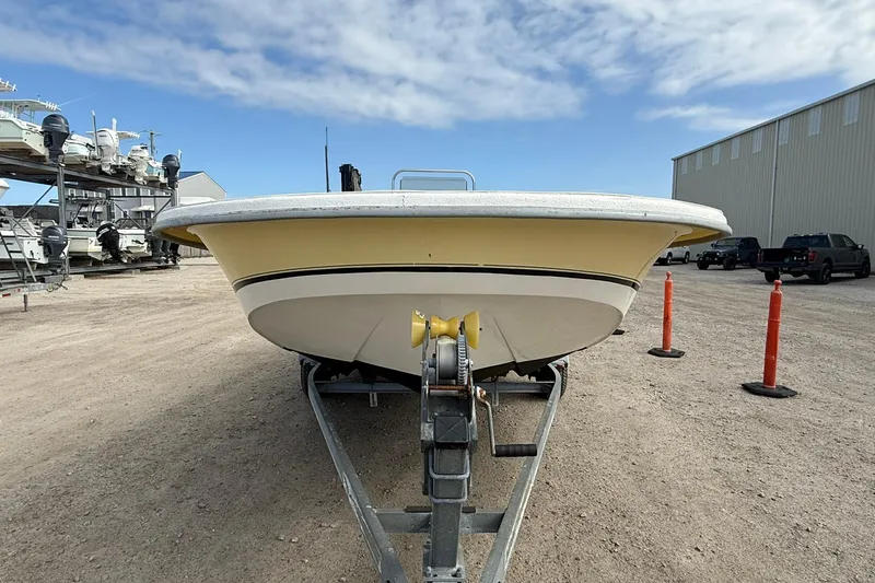 Slide: The Image of 2009 Carolina Skiff 198 DLV boat on trailer, parked outdoors under blue sky. - 10