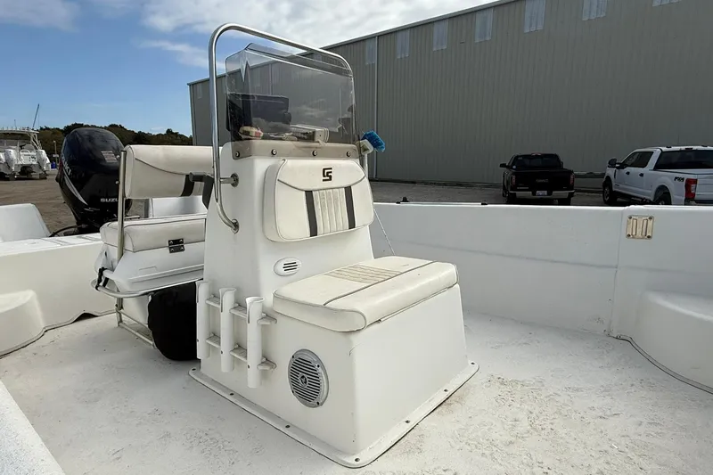 Slide: The Image of 2009 Carolina Skiff 198 DLV boat interior with seating and console, parked outdoors. - 11
