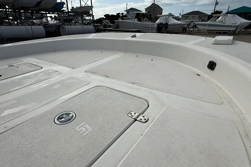 Slide: The Image of 2009 Carolina Skiff 198 DLV boat deck in a marina setting. - 13