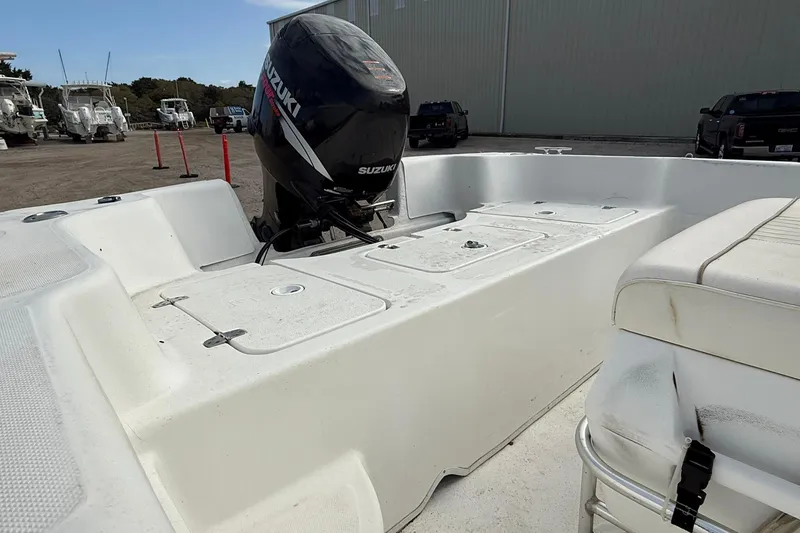 Slide: The Image of 2009 Carolina Skiff 198 DLV boat with Suzuki outboard motor in a marina setting. - 14
