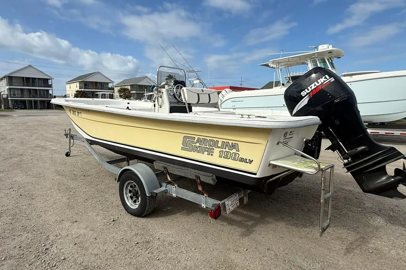 Slide: The Image of 2009 Carolina Skiff 198 DLV boat on trailer with Suzuki outboard motor. - 4