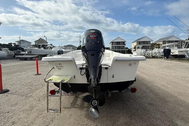 Slide: The Image of 2009 Carolina Skiff 198 DLV boat with outboard motor in a marina setting. - 5