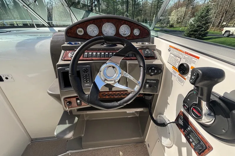 Slide: The Image of 2014 Rinker 290 Express Cruiser helm with steering wheel and control panel. - 10