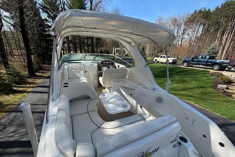 Slide: The Image of 2014 Rinker 290 Express Cruiser with white interior, parked outdoors on a sunny day. - 17