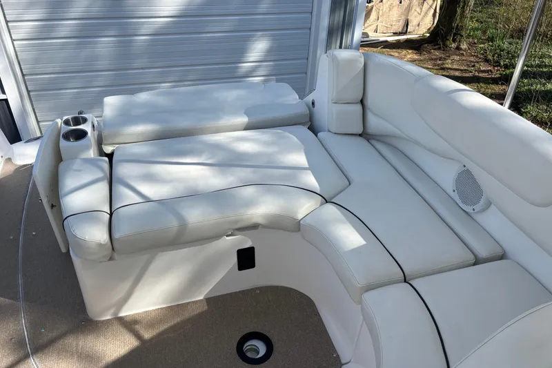 Slide: The Image of 2014 Rinker 290 Express Cruiser interior with white cushioned seating and cup holders. - 25