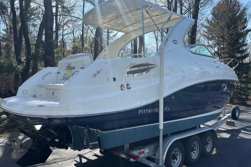 Slide: The Image of 2014 Rinker 290 Express Cruiser on trailer, parked in wooded area. - 35
