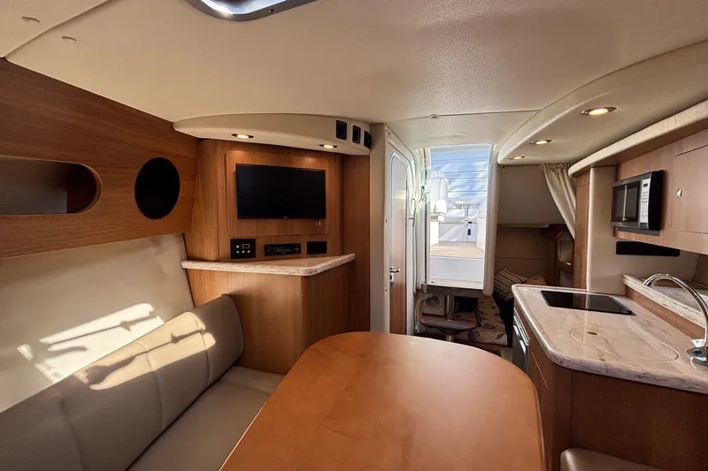 Slide: The Image of Interior of 2014 Rinker 290 Express Cruiser with modern kitchen and seating area. - 4