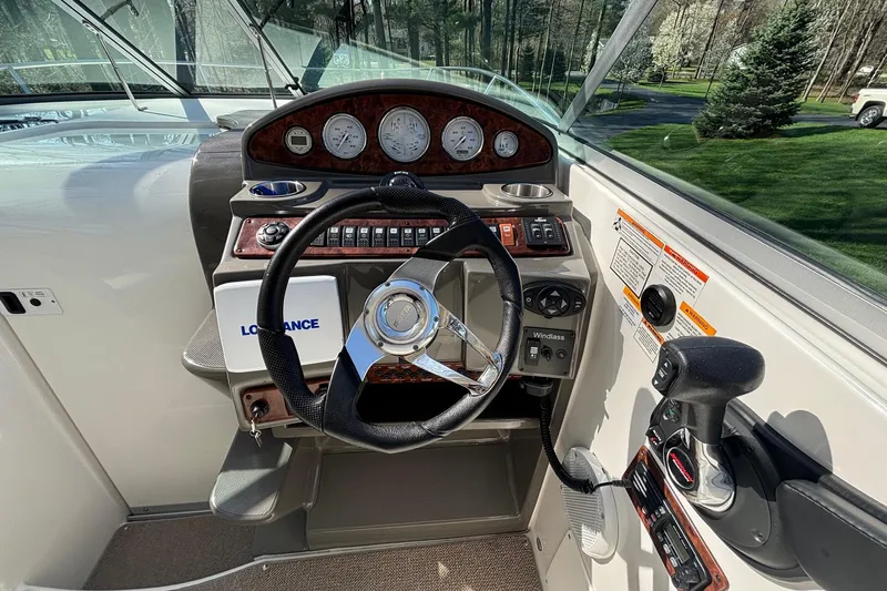 Slide: The Image of 2014 Rinker 290 Express Cruiser helm with steering wheel and control panel. - 9