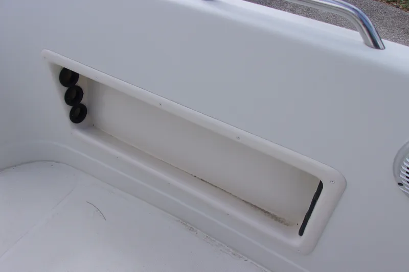 Slide: The Image of Interior detail of a 2008 Tahoe 215 CC boat, featuring storage compartment and cup holders. - 11