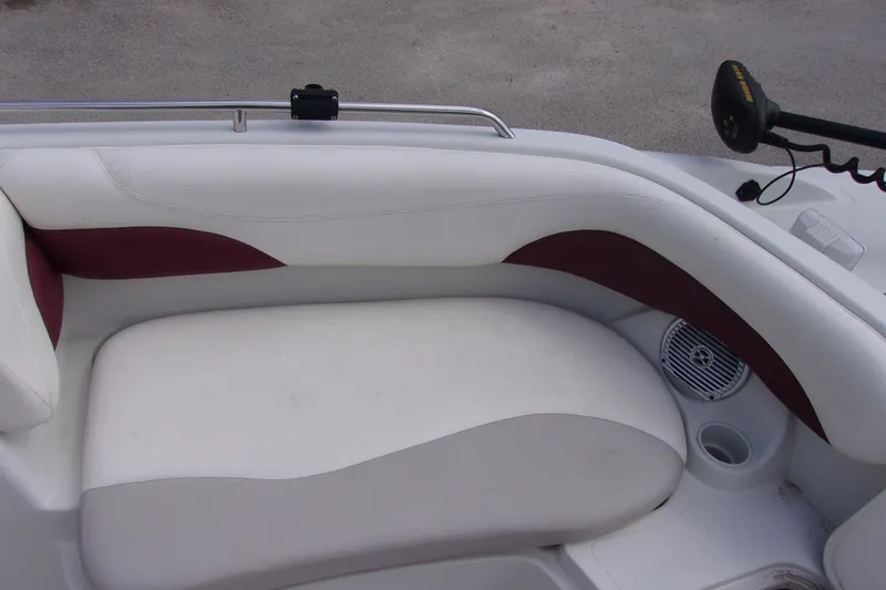 Slide: The Image of 2008 Tahoe 215 CC boat interior with white and maroon seating, speaker, and cup holder. - 16