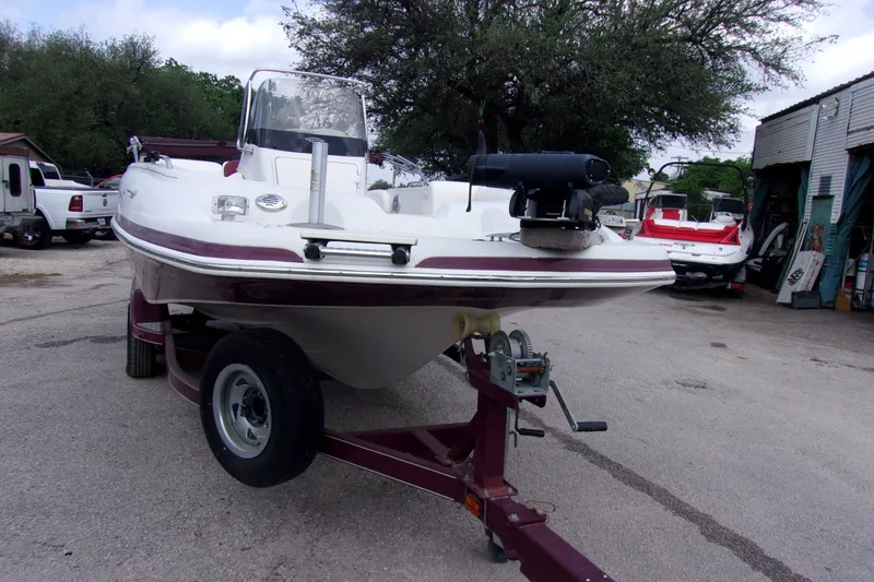 Slide: The Image of 2008 Tahoe 215 CC boat on trailer, parked outdoors near trees and buildings. - 3