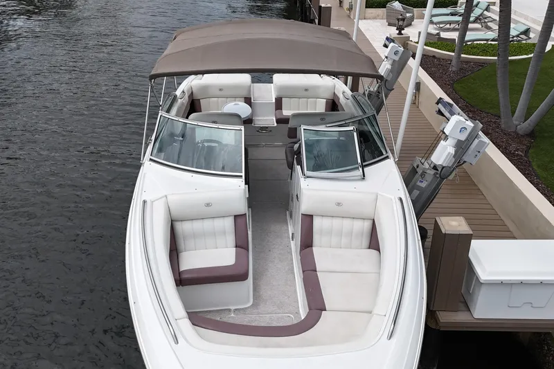 Slide: The Image of 2013 Cobalt 296 boat docked, featuring spacious seating and a canopy. - 13