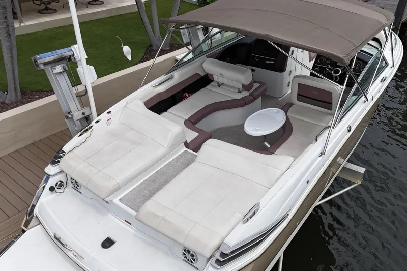 Slide: The Image of 2013 Cobalt 296 boat with spacious seating and canopy, docked by the water. - 15