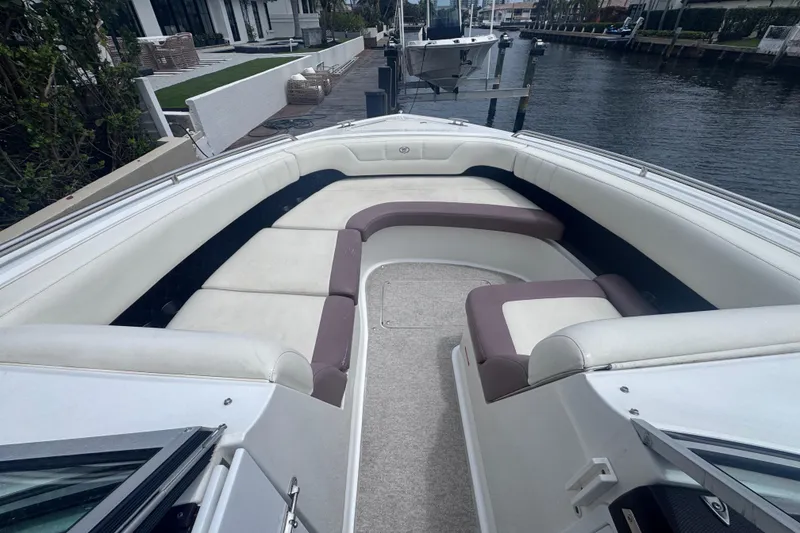Slide: The Image of 2013 Cobalt 296 boat with spacious seating, docked by a waterfront property. - 19