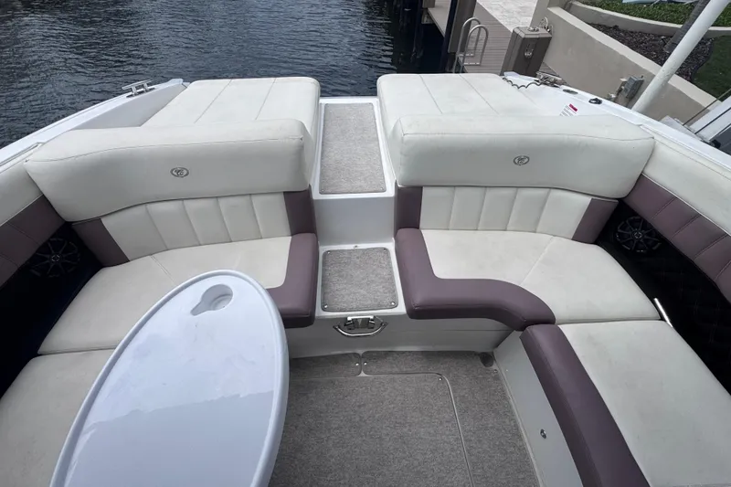 Slide: The Image of 2013 Cobalt 296 boat interior with white and purple seating, near water. - 23