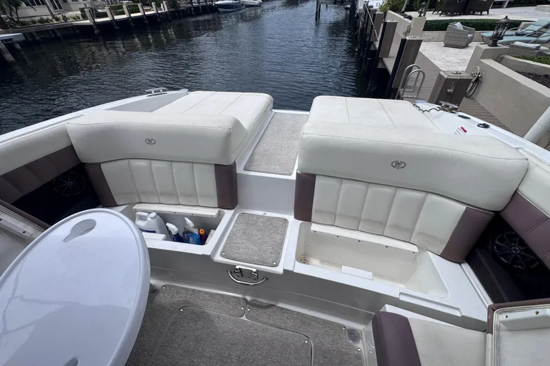 Slide: The Image of 2013 Cobalt 296 boat interior with white seating and storage compartments by the water. - 29