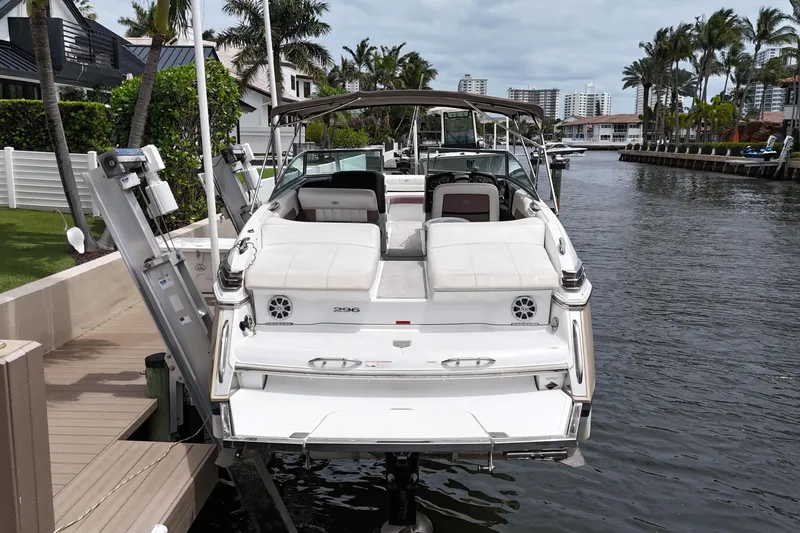 Slide: The Image of 2013 Cobalt 296 boat docked by waterfront homes, surrounded by palm trees. - 32