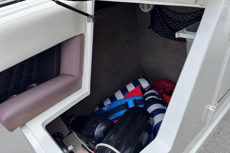 Slide: The Image of Storage compartment in a 2013 Cobalt 296 boat with life jackets and equipment. - 40