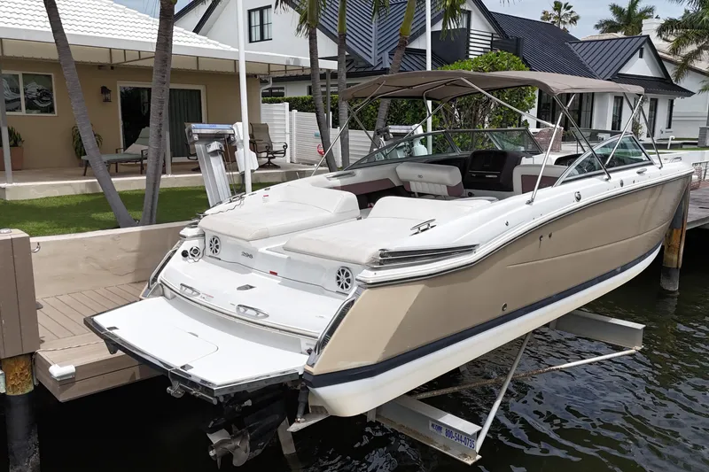 Slide: The Image of 2013 Cobalt 296 boat docked near waterfront homes, featuring sleek design and spacious seating. - 7