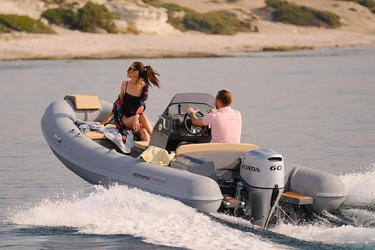 The Image of 2026 Northstar Axis 4.8 boat cruising with two passengers on a sunny day. - 0