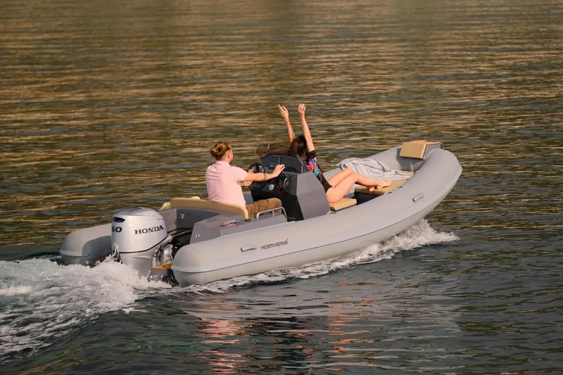 Slide: The Image of 2026 Northstar Axis 4.8 boat cruising with passengers on a sunny day. - 2