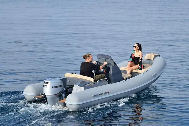 Slide: The Image of 2026 Northstar Axis 4.8 boat cruising with two passengers on calm water. - 5