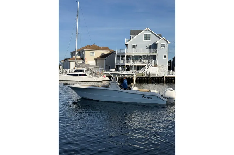 The Image of 2016 Key West Billistic 281 Center Console boat near waterfront homes. - 1