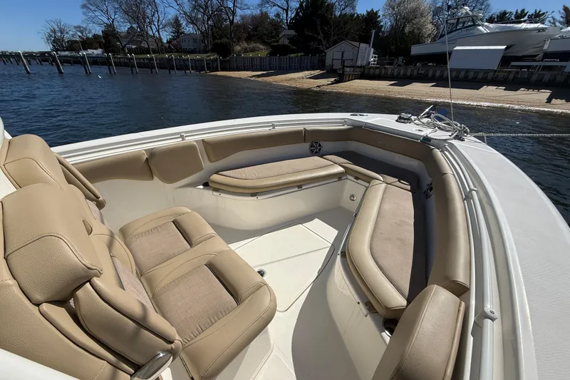 Slide: The Image of 2016 Key West Billistic 281 Center Console boat with beige seating, docked by the shore. - 10
