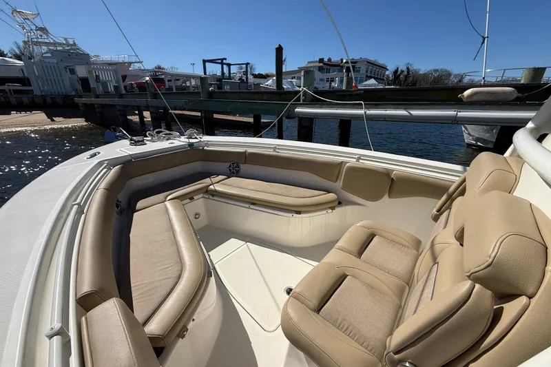 Slide: The Image of 2016 Key West Billistic 281 Center Console boat interior with beige seating at dock. - 18