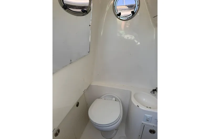 Slide: The Image of 2016 Key West Billistic 281 Center Console boat bathroom with toilet and sink. - 23