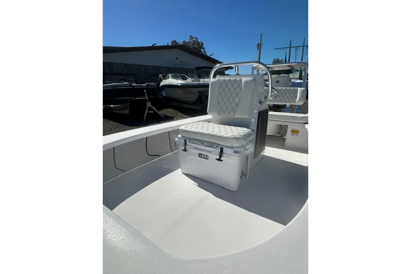 Slide: The Image of 2026 Delta Boatworks Delta D18 with cushioned seating and sleek design in a boatyard. - 11