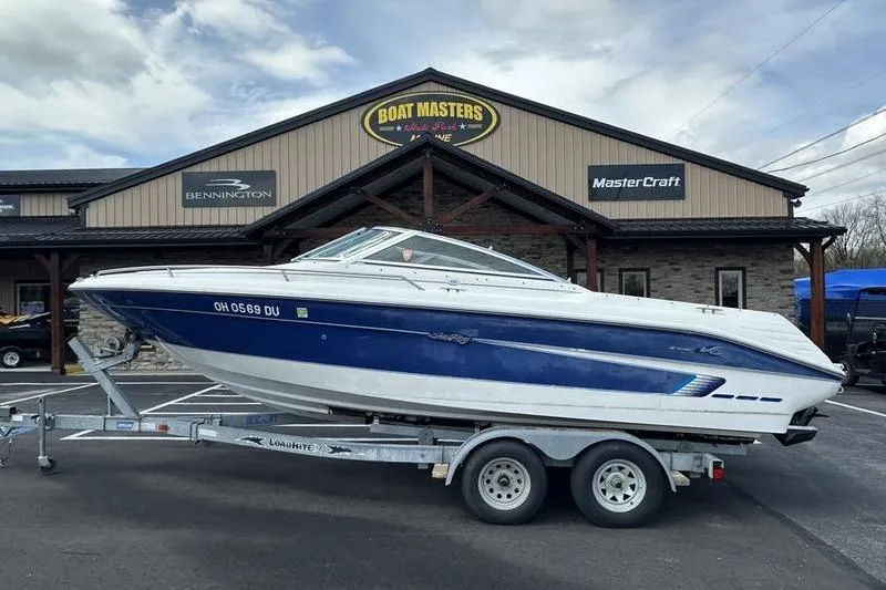 The Image of 1994 Sea Ray 220 Overnighter Signature boat on trailer outside dealership. - 1