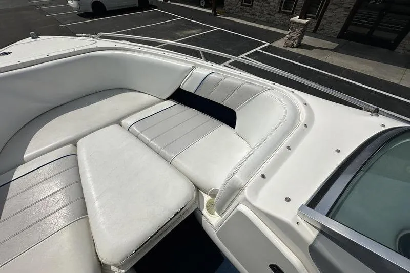 Slide: The Image of 1994 Sea Ray 220 Overnighter Signature boat interior with white cushioned seating. - 11